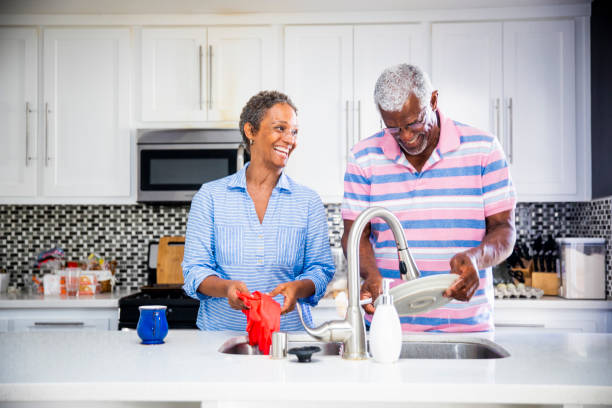 Senior Black Couple Doing the Dishes A senior couple doing the dishes washing dishes photos stock pictures, royalty-free photos & images