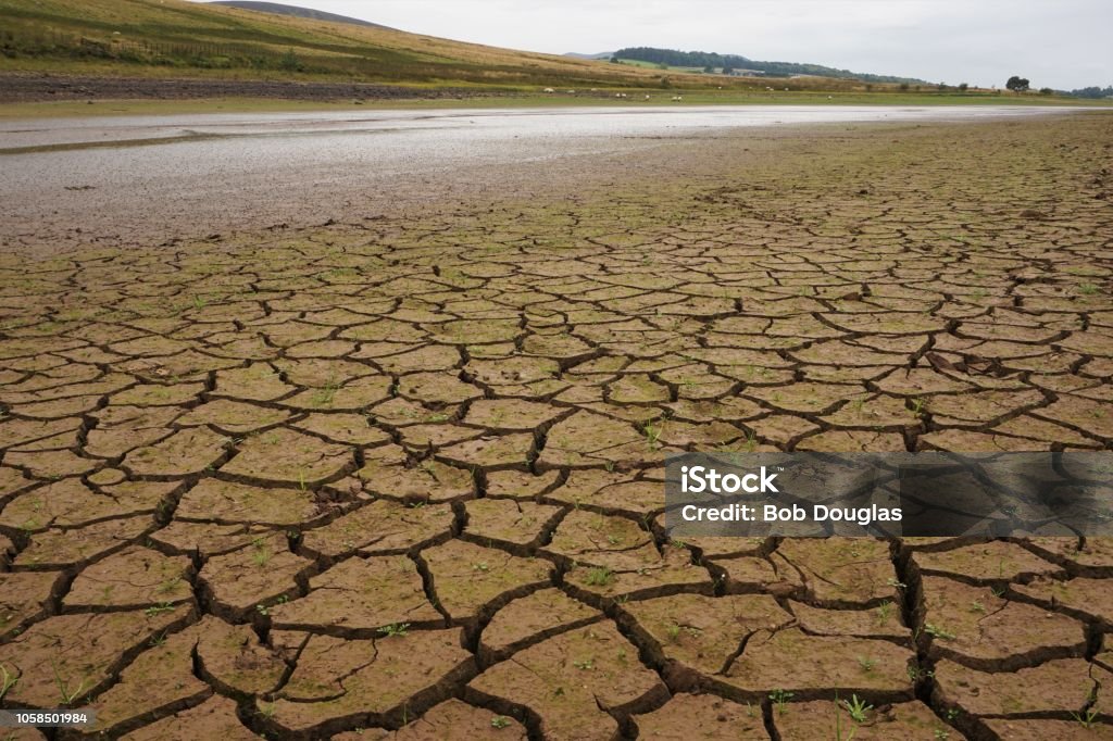 Pentland Hills Drought Pentland Hills, Edinburgh, Scotland - August 20 2018: Following a long hot summer across most of the UK, not much water remains in Threipmuir Reservoir in the Pentland Hills, near Edinburgh. This view is looking across part of the deeply  cracked reservoir bed which would normally be under water. Drought Stock Photo