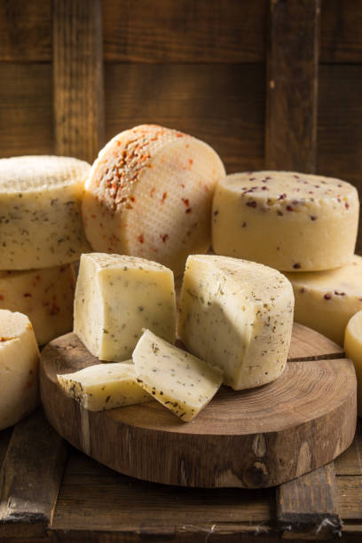 istock Assorted caciotta cheese on wooden board on dark background 1058507628