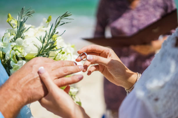 die braut kleider den ring für den bräutigam bei einer hochzeitszeremonie auf einer tropischen insel. händen frischvermählten, close-up. - women hawaii islands beach beauty in nature stock-fotos und bilder