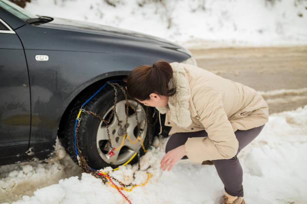 istock Beautiful woman installing snow chain on her car 1058508746