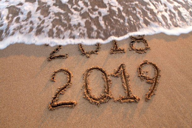 istock New year 2019 and 2018 on sandy beach with waves 1058508840