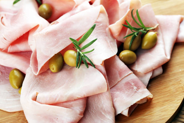 istock Sliced ham on wooden background. Fresh prosciutto. Pork ham sliced. 1058508988