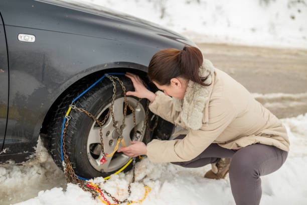 istock Beautiful woman installing snow chain on her car 1058509092