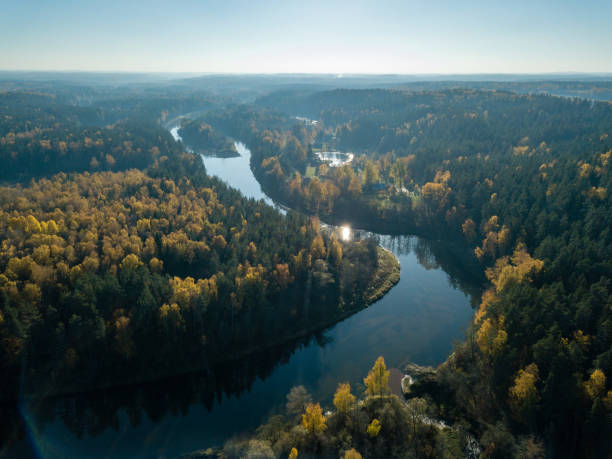 istock drone image. aerial view of wavy river in autumn colored forest 1058518892
