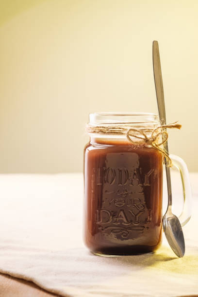 istock hot chocolate in a tall glass jar. 1058519636