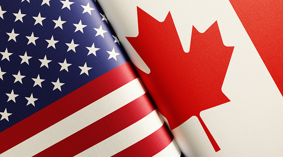American and Canadian flag pair. Horizontal composition with copy space and selective focus.