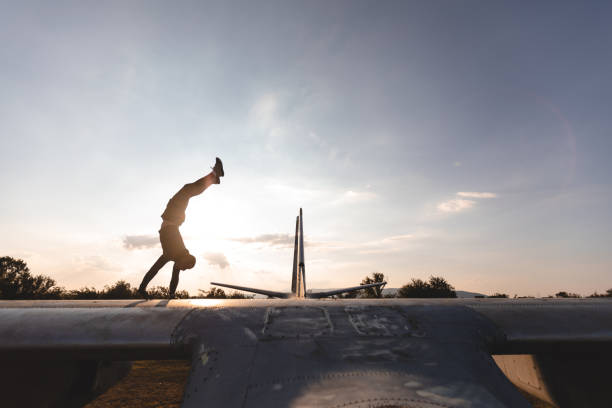 istock Athlete and a stuntman doing a handstand on a abandoned airplane 1058522546