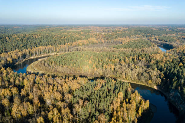 istock drone image. aerial view of wavy river in autumn colored forest 1058523262