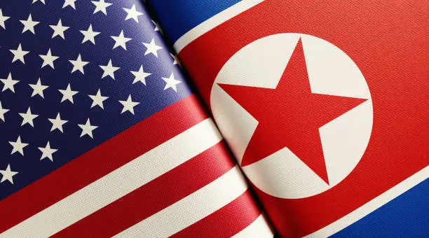 American and North Korean flag pair. Horizontal composition with copy space and selective focus.