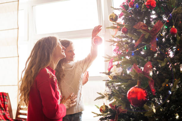 istock Mom and daughter decorate the Christmas tree 1058525598