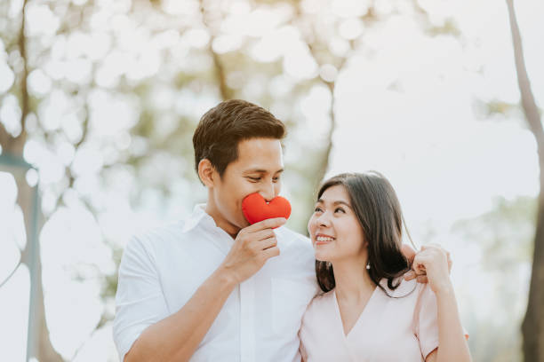 счастливая азиатская пара в любви в парке - couple engagement valentines day heart shape стоковые фото и изображения