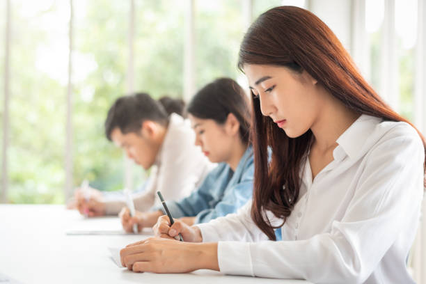 istock woman sitting in a row having a test in class 1058526702