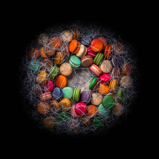French macarons closeup large colorful overhead arrangement on dark background