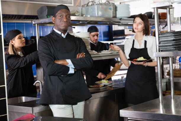 istock Smiling chef cook is posing on kitchen in restaurant. 1058540282