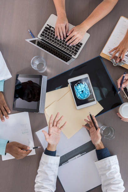 istock Arial view of unrecognizable doctors sitting at around conference table 1058542190