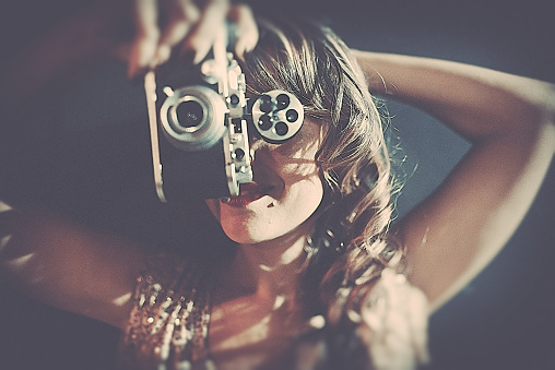 Vintage woman making photos with old camera