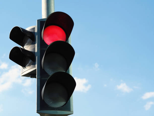 istock traffic light with red light and blue sky in background. 1058547884