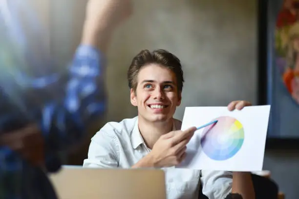 Photo of Happy graphic designer holding color diagram in his hand