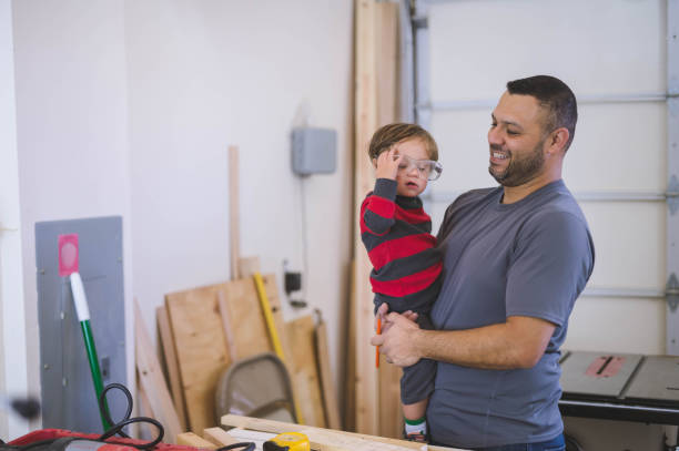 istock Hispanic dad working on a project in his garage with his young son 1058584380