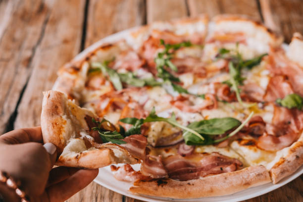 istock Woman's hand grab slice of pizza 1058584670