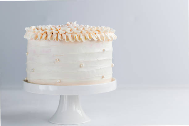 bella torta di compleanno decorata con perle commestibili su sfondo neutro bianco. copiare lo spazio. concetto di celebrazione. torta a strati alla moda. orizzontale. - buttercream foto e immagini stock