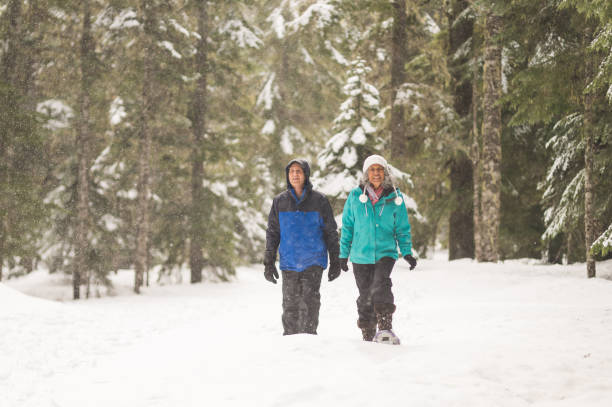 istock A senior couple snowshoeing in the forest 1058586802