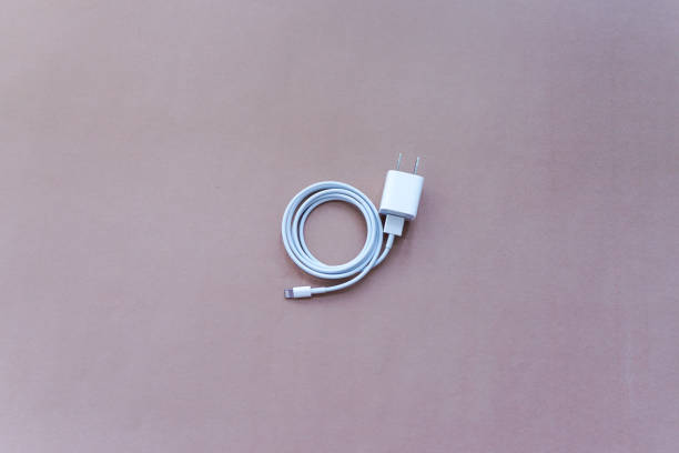 istock Smartphone Charger with USB Cable on Brown Background Top View 1058590124