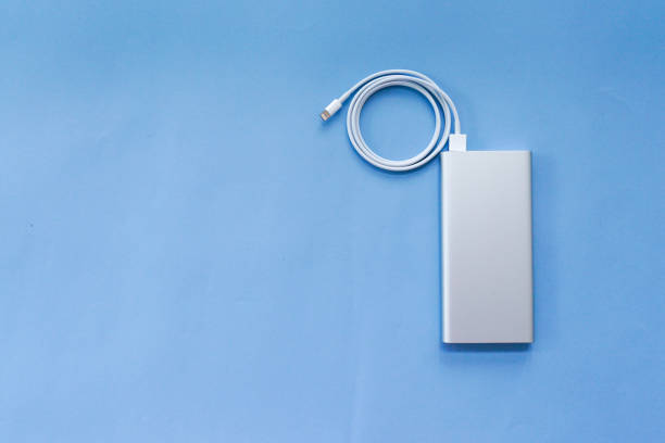 Silver Aluminum Power Bank with USB Cable Isolated on Blue Background Top View