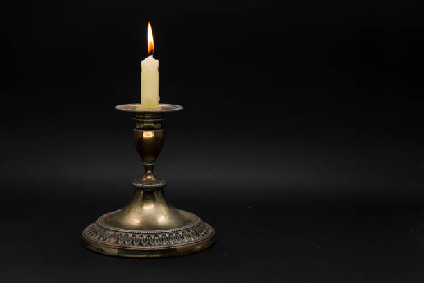 istock Vintage candle holder with lighted candle isolated in black background 1058592402