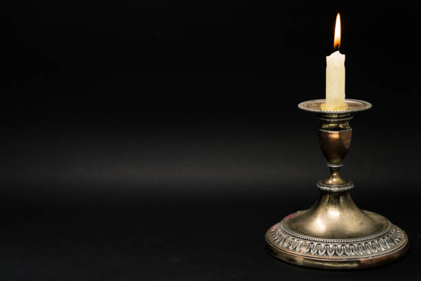 istock Vintage candle holder with lighted candle isolated in black background 1058592408