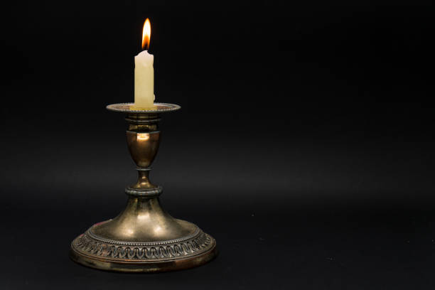 istock Vintage candle holder with lighted candle isolated in black background 1058592416