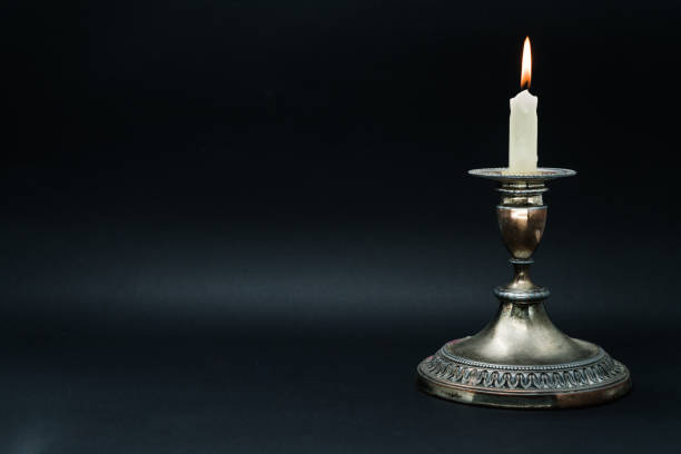 istock Old silver candle holder with lighted candle 1058592810