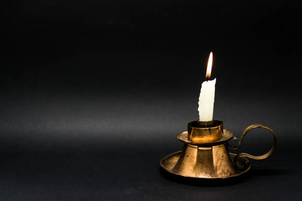 istock candle fire in a candle holder isolated in black 1058593434