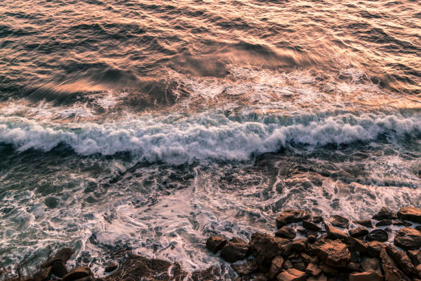 istock Waves Breaking on the rocks during golden hour 1058595504