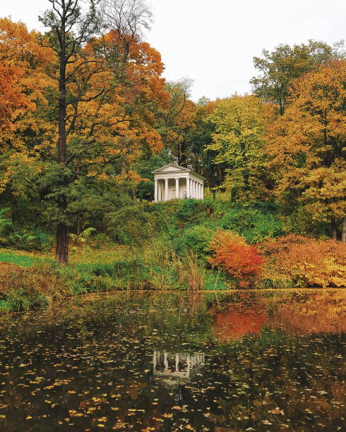istock Ancient small building between trees, autumn, lake 1058605930