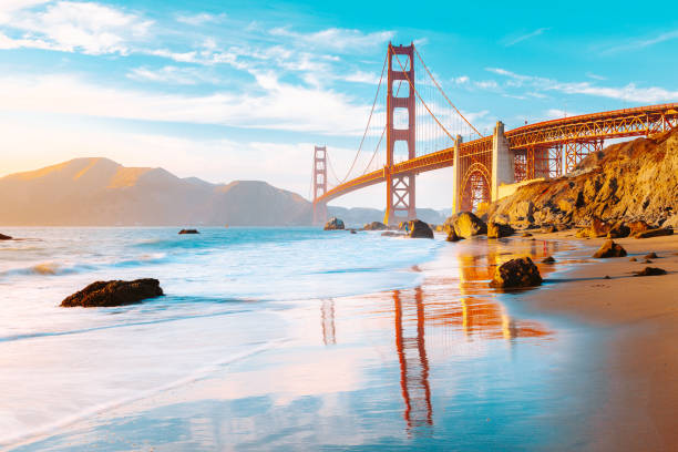 Golden Gate Bridge at sunset, San Francisco, California, USA Classic panoramic view of famous Golden Gate Bridge seen from scenic Baker Beach in beautiful golden evening light on a sunny day with blue sky and clouds in summer, San Francisco, California, USA baker beach stock pictures, royalty-free photos & images