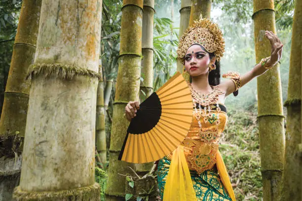 Photo of Young traditional Bali dancer in a bamboo forest