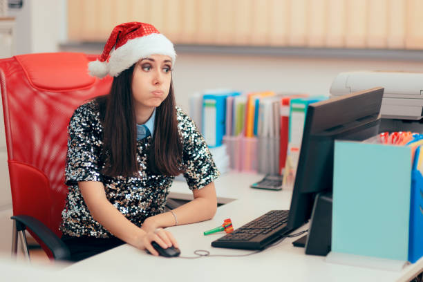 donna triste che trascorre le vacanze di natale in ufficio - holiday emotional stress christmas santa claus foto e immagini stock