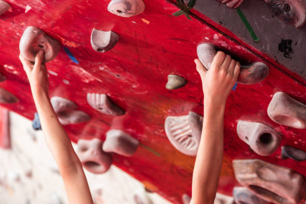Close-up view of an artificial climbing wall with various colorful holds. Perfect for indoor bouldering and rock climbing training, this wall offers a challenging and engaging workout for enthusiasts.
