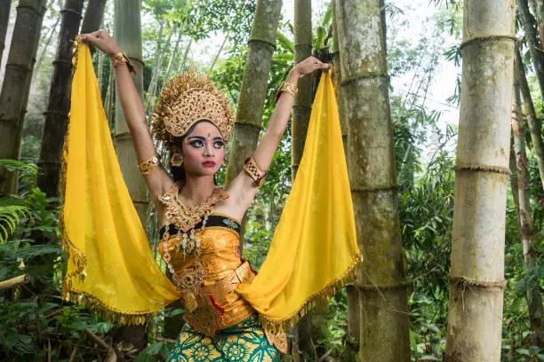Photo of Young traditional Bali dancer in a bamboo forest