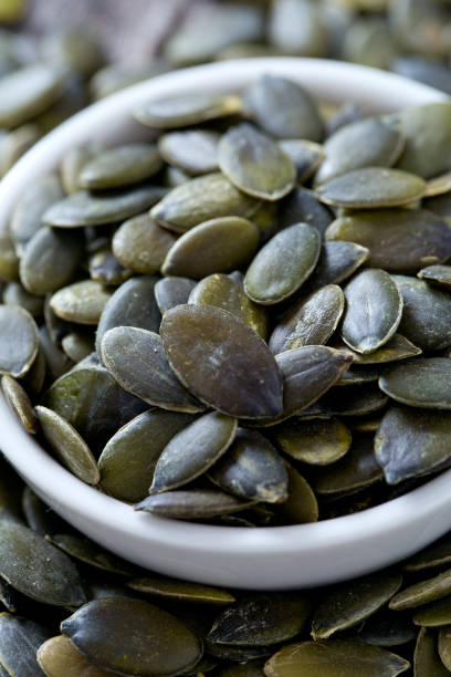 istock pumpkin seeds on wooden surface 1058633606