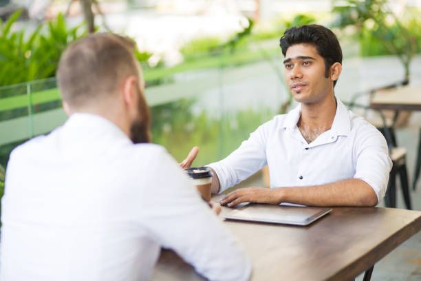 istock Confident handsome Asian manager talking to business partner 1058640976