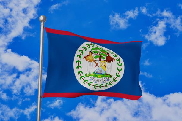 istock Belize national flag waving isolated in the blue cloudy sky 1058641168