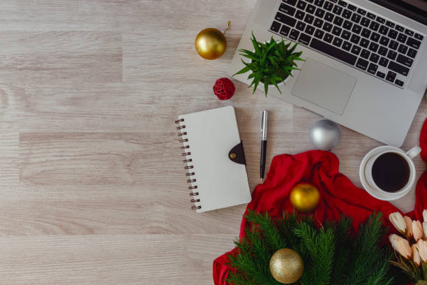 istock Laptop and notepad with ornaments balls on wood table. 1058641224