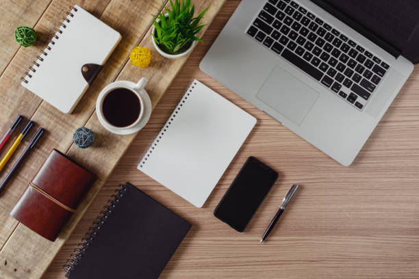 istock Office supply items, laptop and coffee on rustic wood. 1058641286