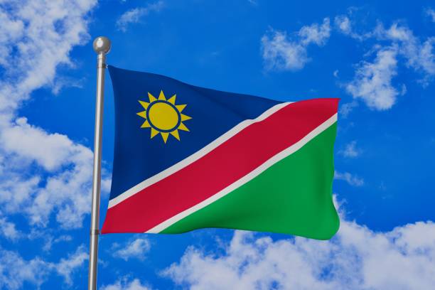 istock Namibia national flag waving isolated in the blue cloudy sky 1058642636