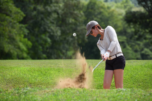 istock Asian woman golfer hitting a bunker shot 1058644494