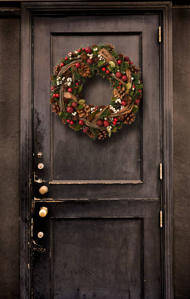 черная дверь, висящая рождественский венок. - front door doorknob door wood стоковые фото и изображения