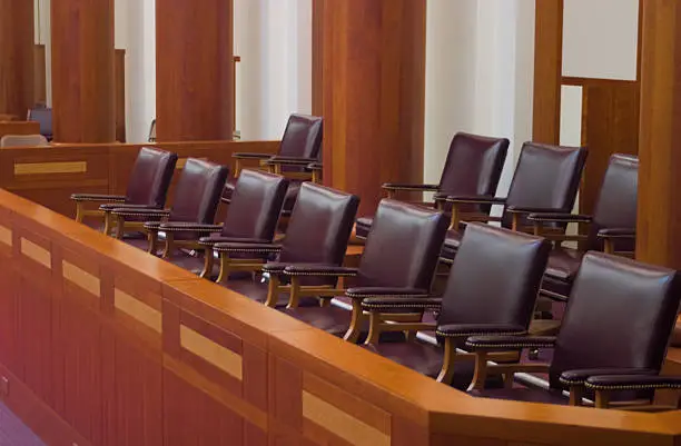 Empty jury box in a large, modern courtroom.